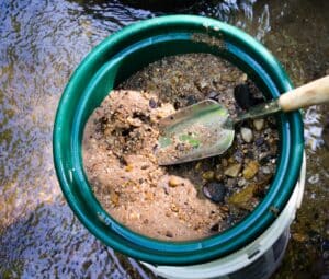 Sift and classify mineral rich soil in gold panning classifier. Outdoor adventure of prospecting and panning for gold.