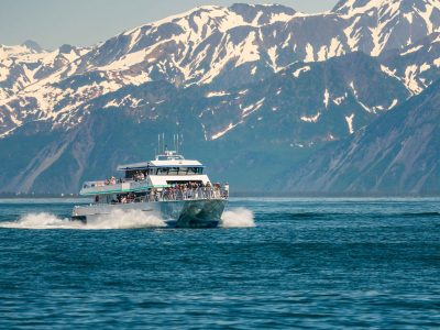 Seward, Alaska - 3 June 2022: Kenai Fjord wildlife tour boat by snow mountains